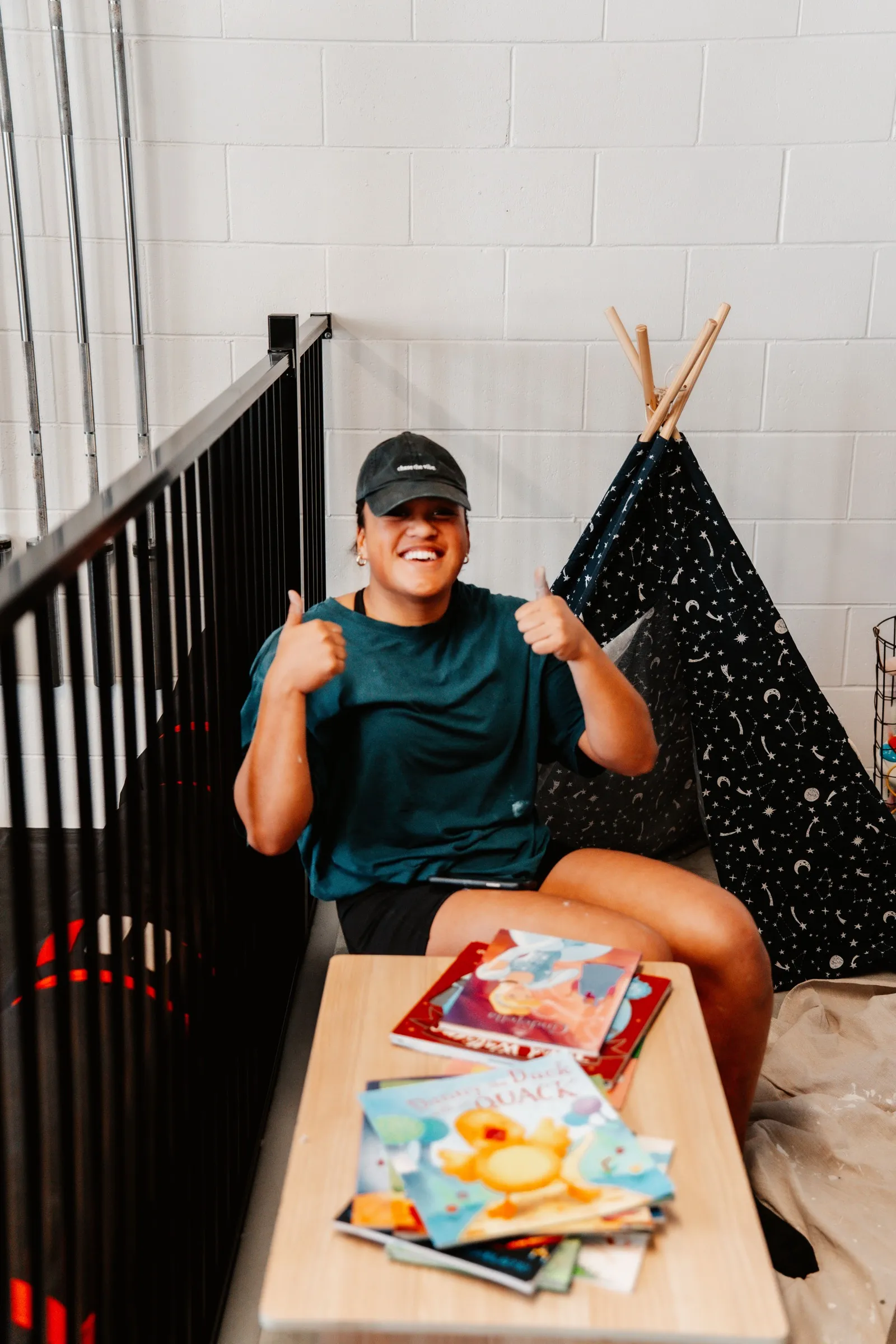 The kids’ corner — teepee and a stack of picture books.