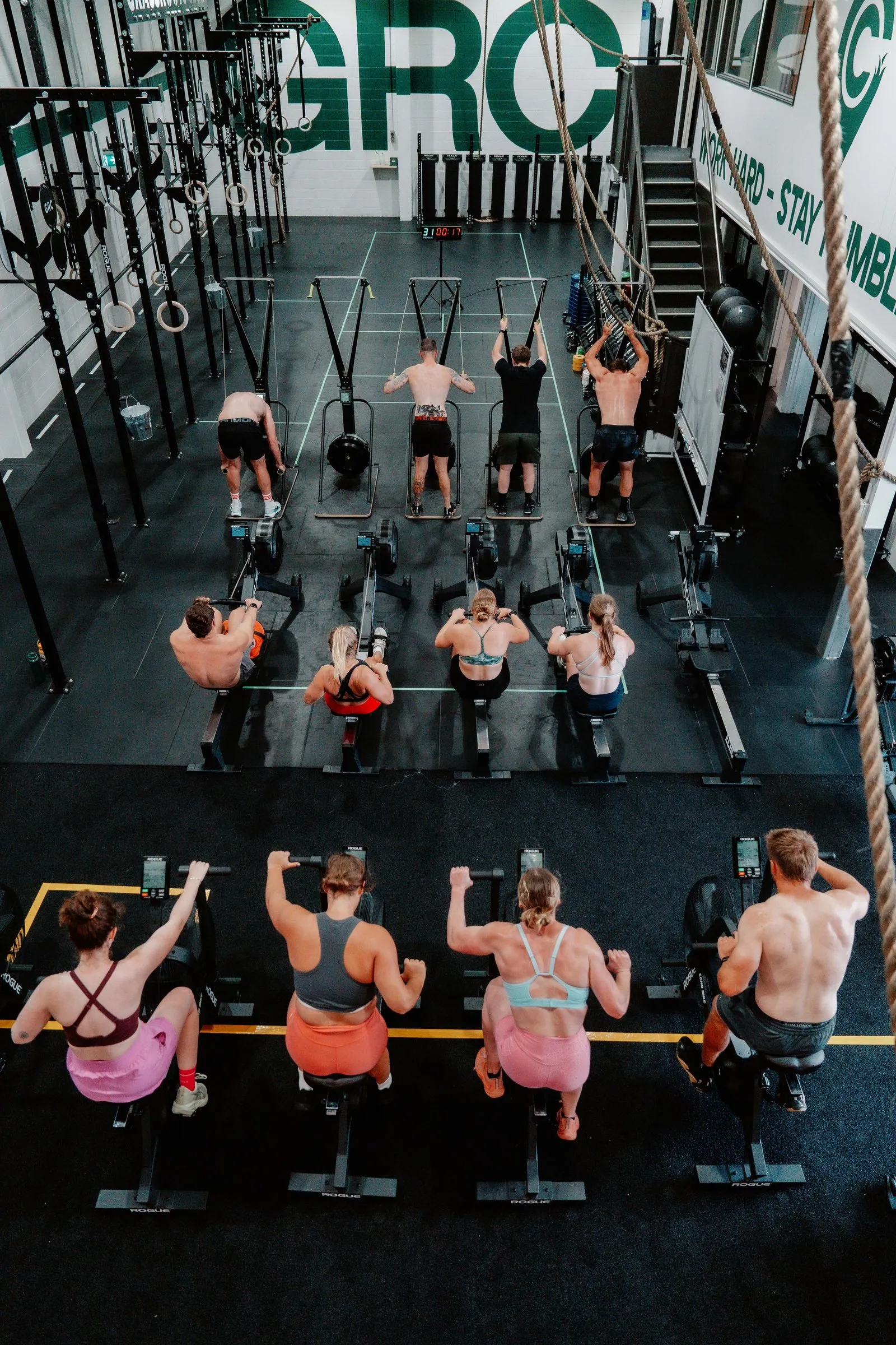 EMOM Club from above — rowers, bikes and pull-up stations working in formation.
